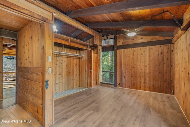 interior space featuring light hardwood / wood-style flooring, wood walls, wood ceiling, and lofted ceiling with beams