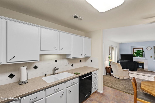 kitchen with backsplash, dishwasher, white cabinetry, and sink