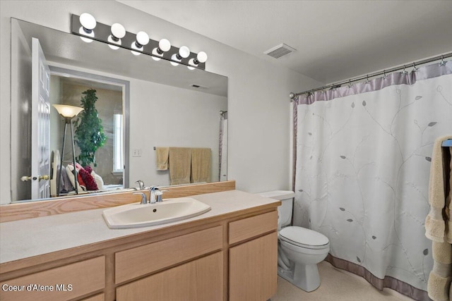 bathroom featuring vanity, toilet, and curtained shower