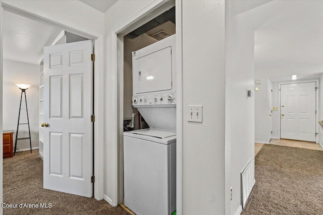 laundry room with stacked washer and clothes dryer and carpet flooring