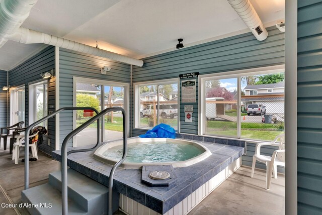 sunroom featuring a hot tub