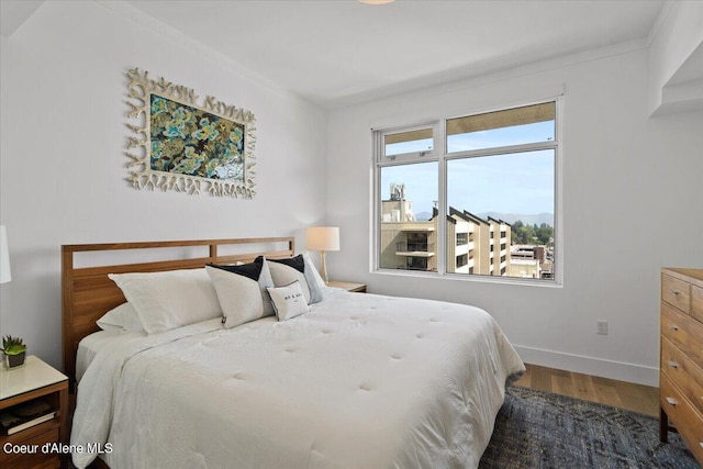 bedroom with crown molding and wood-type flooring