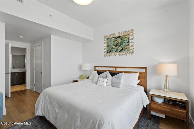 bedroom featuring dark wood-type flooring and ensuite bathroom