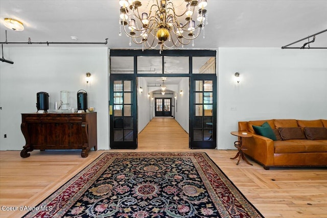 foyer with hardwood / wood-style floors and a notable chandelier