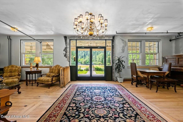 interior space featuring plenty of natural light, hardwood / wood-style floors, and a chandelier