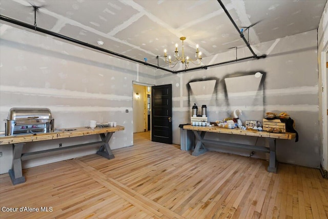 miscellaneous room featuring hardwood / wood-style floors and an inviting chandelier