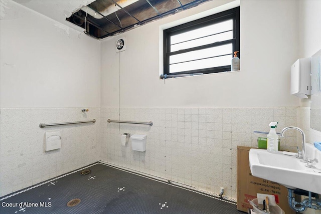 bathroom featuring tile walls and sink