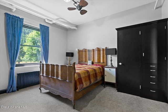 carpeted bedroom with radiator and ceiling fan