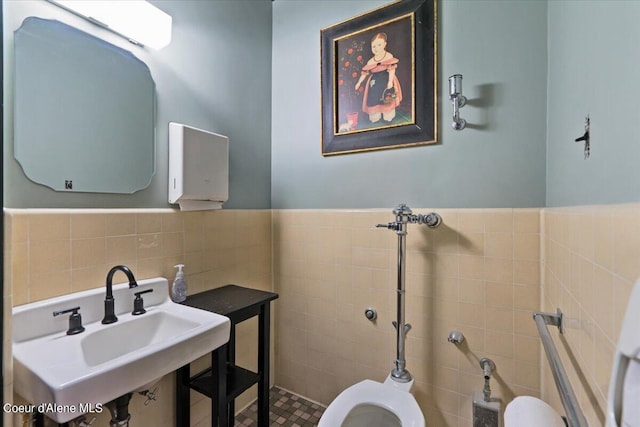 bathroom featuring tile walls, toilet, and sink