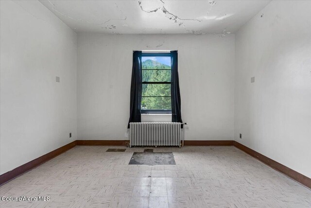 unfurnished room featuring radiator