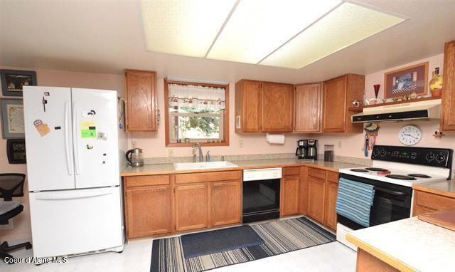 169 Westfall Ln, Kamiah, ID 83536 - kitchen featuring freestanding refrigerator, dishwashing machine, under cabinet range hood, a sink, and range with electric stovetop