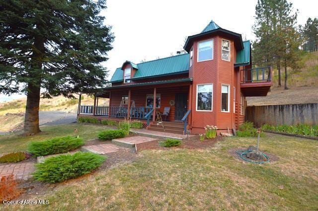169 Westfall Ln, Kamiah, ID 83536 - back of property with metal roof, a lawn, and covered porch