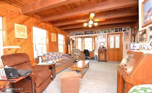 169 Westfall Ln, Kamiah, ID 83536 - living area with ceiling fan, wood walls, beamed ceiling, and carpet flooring