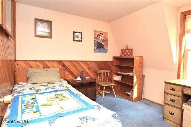 169 Westfall Ln, Kamiah, ID 83536 - bedroom featuring wood walls, carpet, and wainscoting