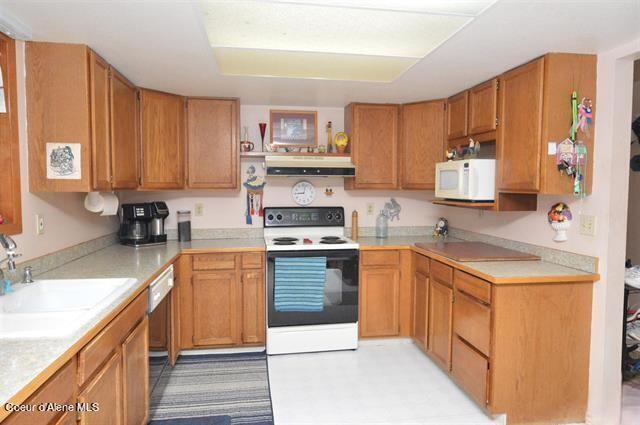 169 Westfall Ln, Kamiah, ID 83536 - kitchen with under cabinet range hood, white appliances, light countertops, and a sink