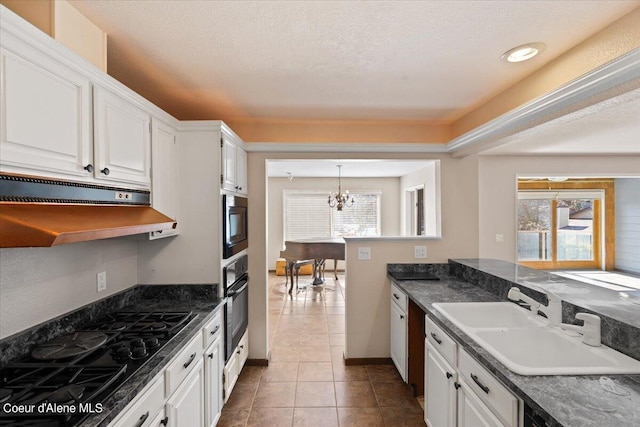 kitchen featuring a chandelier, a healthy amount of sunlight, sink, and white cabinets