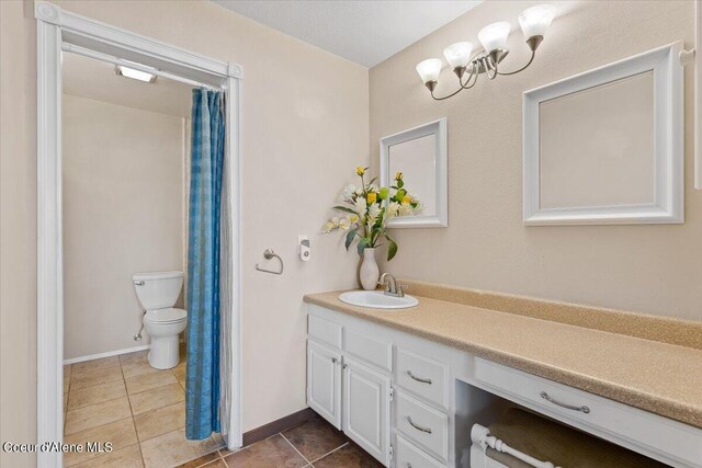 bathroom featuring tile patterned flooring, vanity, and toilet