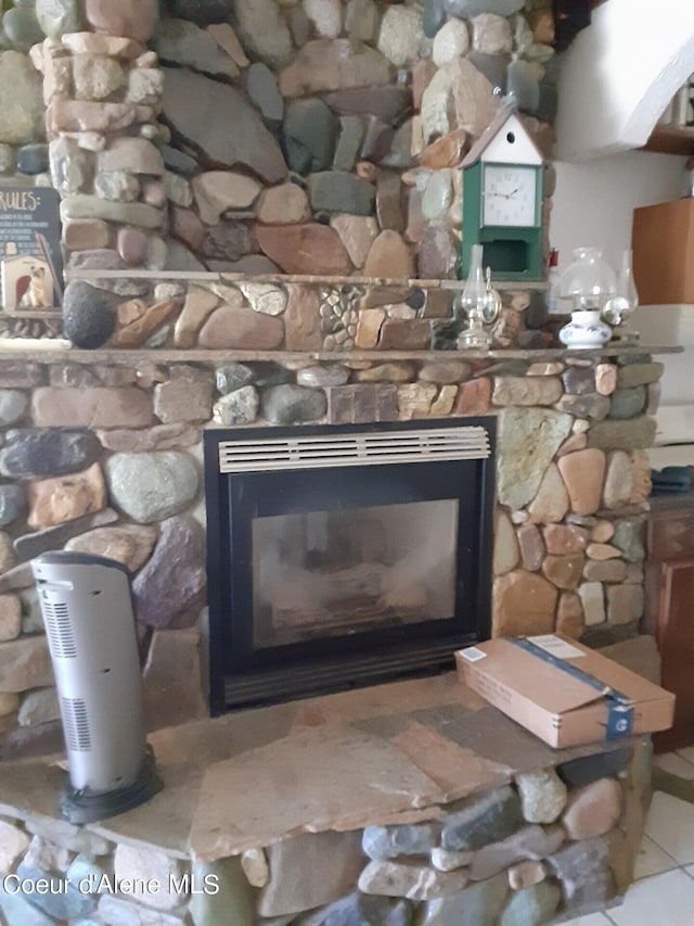 interior details with a stone fireplace and tile patterned flooring