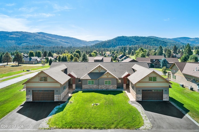 craftsman house featuring a mountain view, a garage, and a front lawn