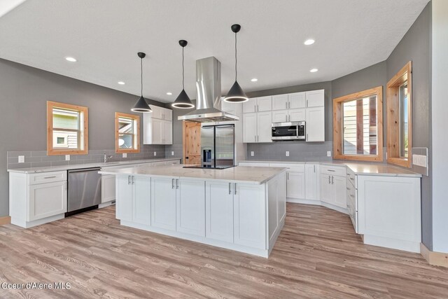 kitchen featuring island range hood, a kitchen island, stainless steel appliances, and plenty of natural light