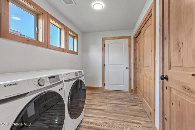 washroom featuring light hardwood / wood-style floors and washer and dryer