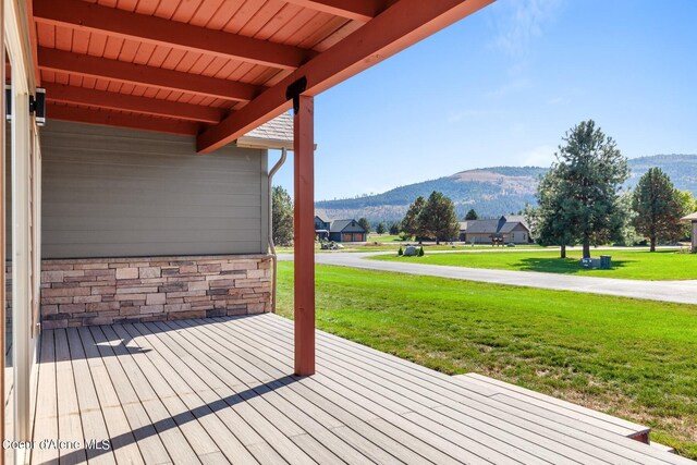 deck with a yard and a mountain view