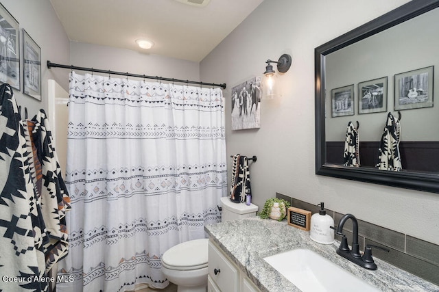 bathroom with vanity, toilet, and curtained shower