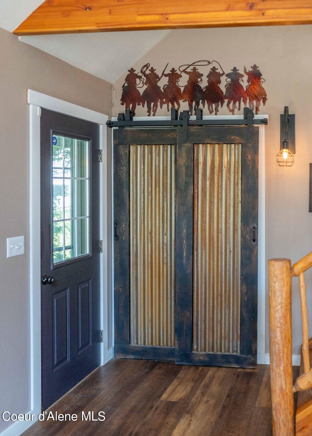 entryway with dark wood-type flooring and a barn door