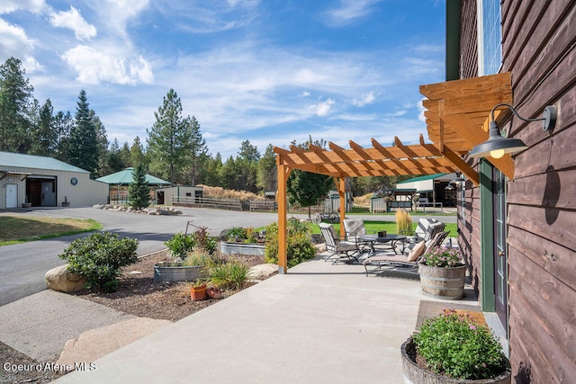 view of patio / terrace with a pergola, an outdoor structure, and a garage