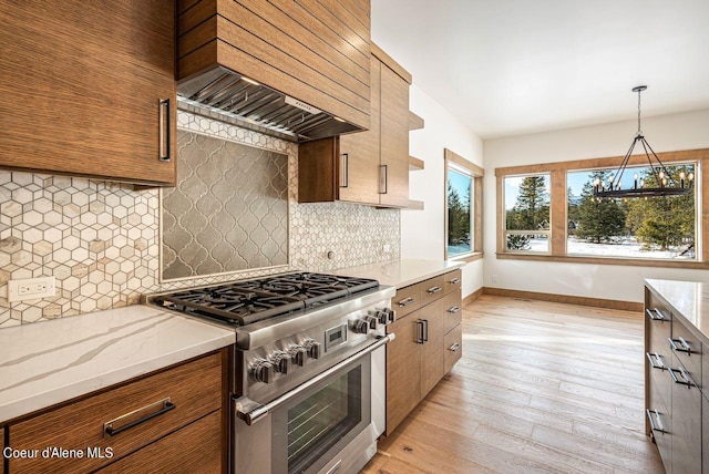 kitchen featuring backsplash, custom exhaust hood, high end stove, and light wood-type flooring