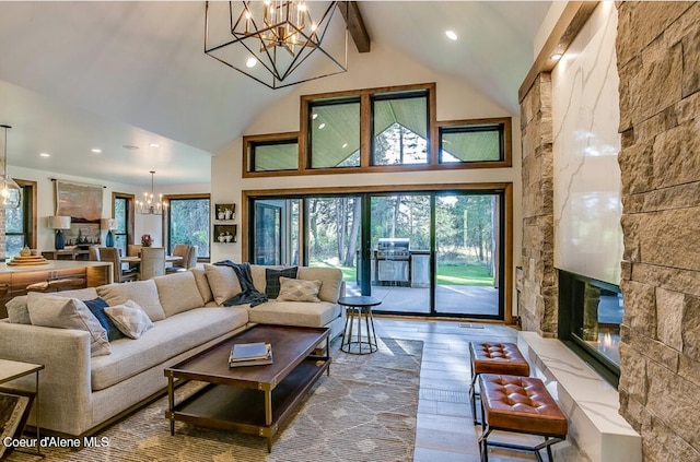 living room with wood-type flooring, beam ceiling, an inviting chandelier, and plenty of natural light