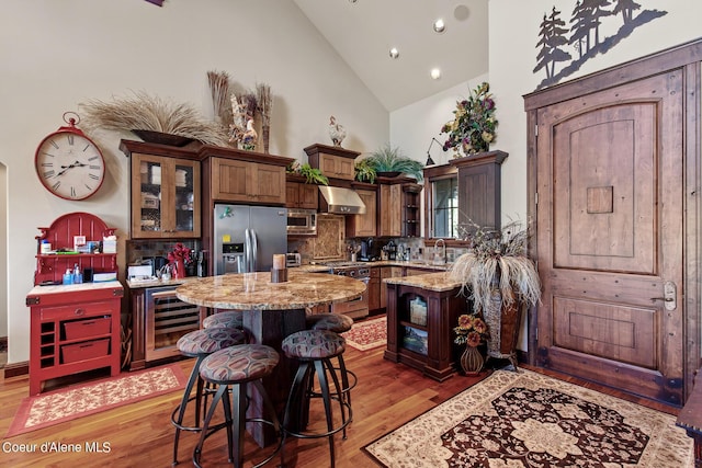 17023 S Citrine Dr, Coeur Dalene, ID 83814 - kitchen featuring appliances with stainless steel finishes, a sink, beverage cooler, extractor fan, and a center island