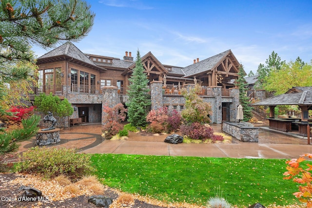 17023 S Citrine Dr, Coeur Dalene, ID 83814 - back of property featuring an outdoor fire pit, stone siding, and a patio