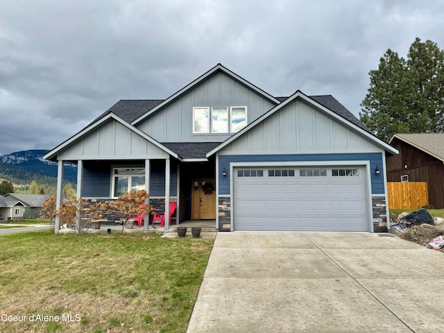 craftsman house with a front yard, a porch, a garage, and a mountain view