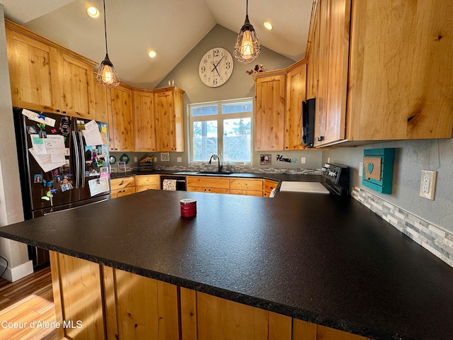 kitchen with kitchen peninsula, hanging light fixtures, black appliances, and vaulted ceiling