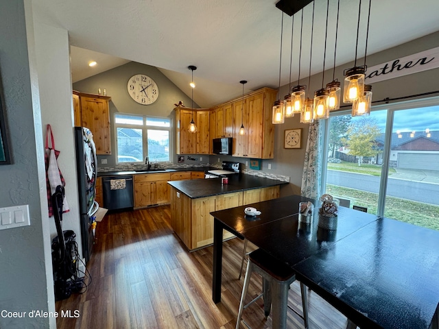 kitchen featuring a center island, black appliances, hanging light fixtures, vaulted ceiling, and dark hardwood / wood-style floors