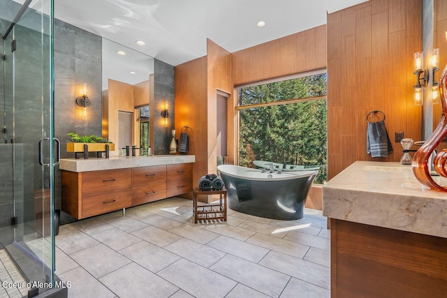 bathroom with wooden walls, tile patterned flooring, vanity, and separate shower and tub