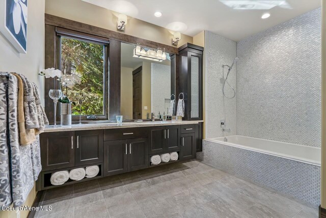 bathroom featuring tiled shower / bath combo, tile patterned flooring, and vanity