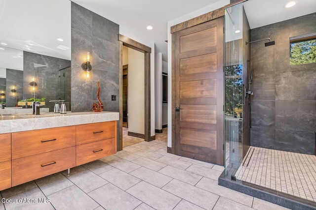 bathroom with tile walls, vanity, tile patterned floors, and a shower with shower door