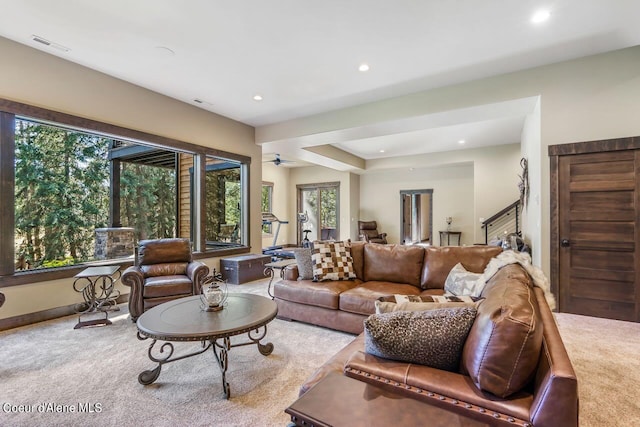 carpeted living room with ceiling fan