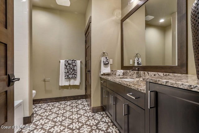 bathroom featuring vanity, tile patterned flooring, and toilet