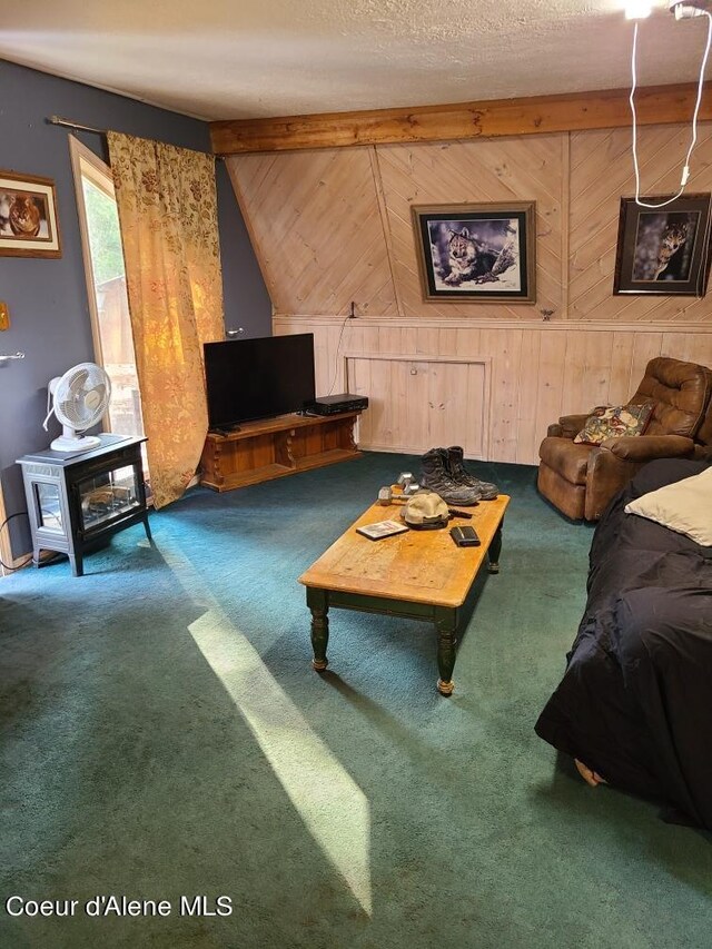 living room with wood walls, lofted ceiling with beams, a textured ceiling, and carpet