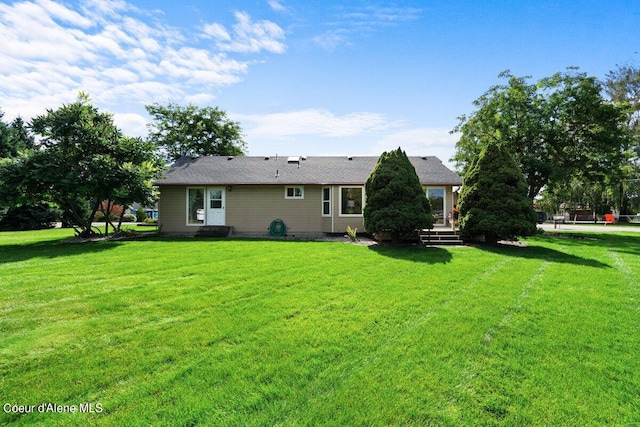 rear view of house with a yard