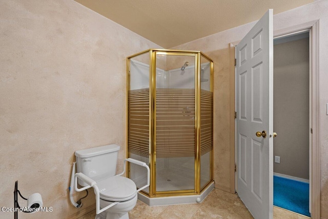 bathroom with a shower with shower door and toilet