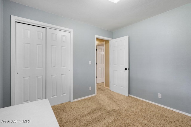 unfurnished bedroom featuring a closet and light colored carpet