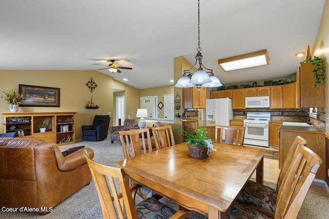 dining area with ceiling fan with notable chandelier, lofted ceiling, light carpet, and sink