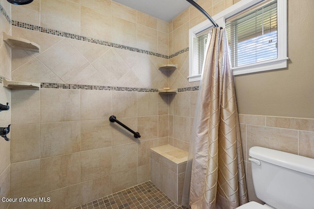 bathroom with a shower with curtain, tile walls, and toilet