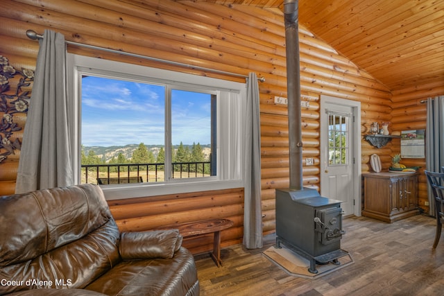 living room with a wood stove, hardwood / wood-style flooring, wood ceiling, and rustic walls