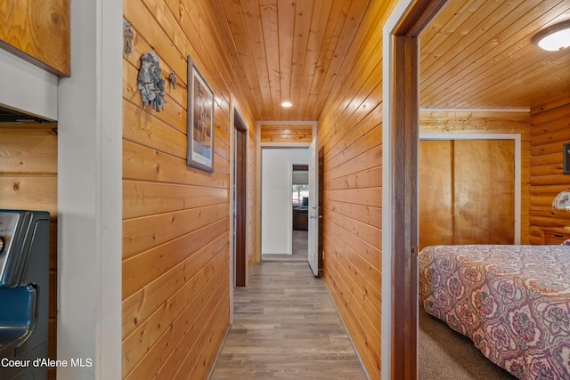 hallway featuring washer / dryer, hardwood / wood-style flooring, wooden walls, and wood ceiling