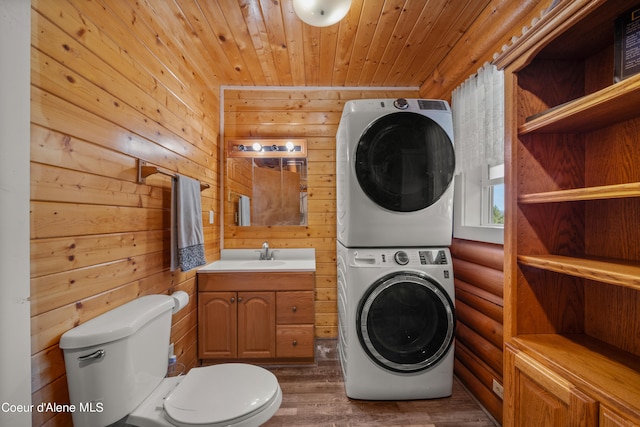 laundry room with wood ceiling, wood walls, sink, dark hardwood / wood-style floors, and stacked washer / drying machine